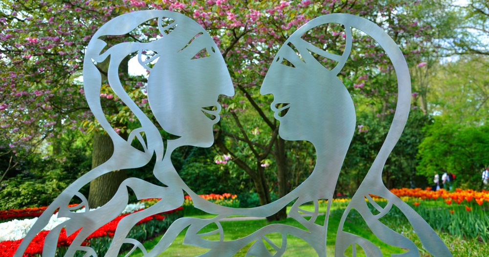 Stainless steel silhouette figure sculpture in a garden