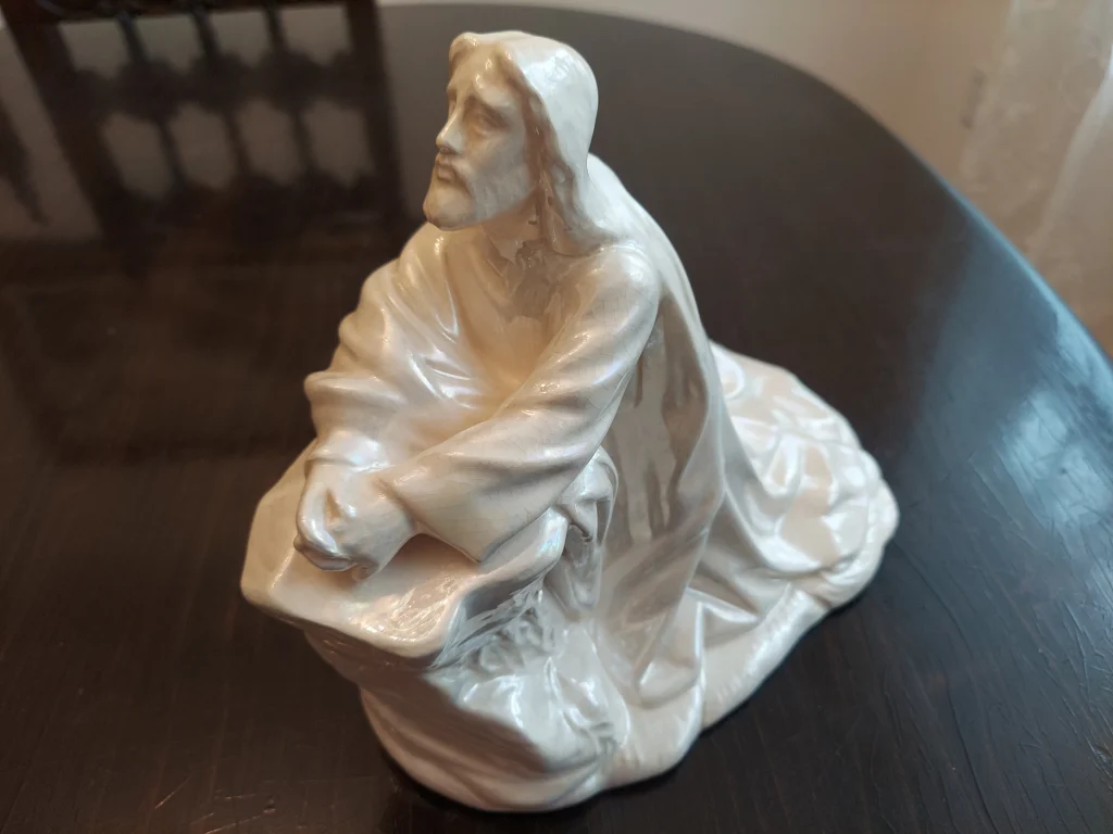 A statue of Jesus kneeling in prayer