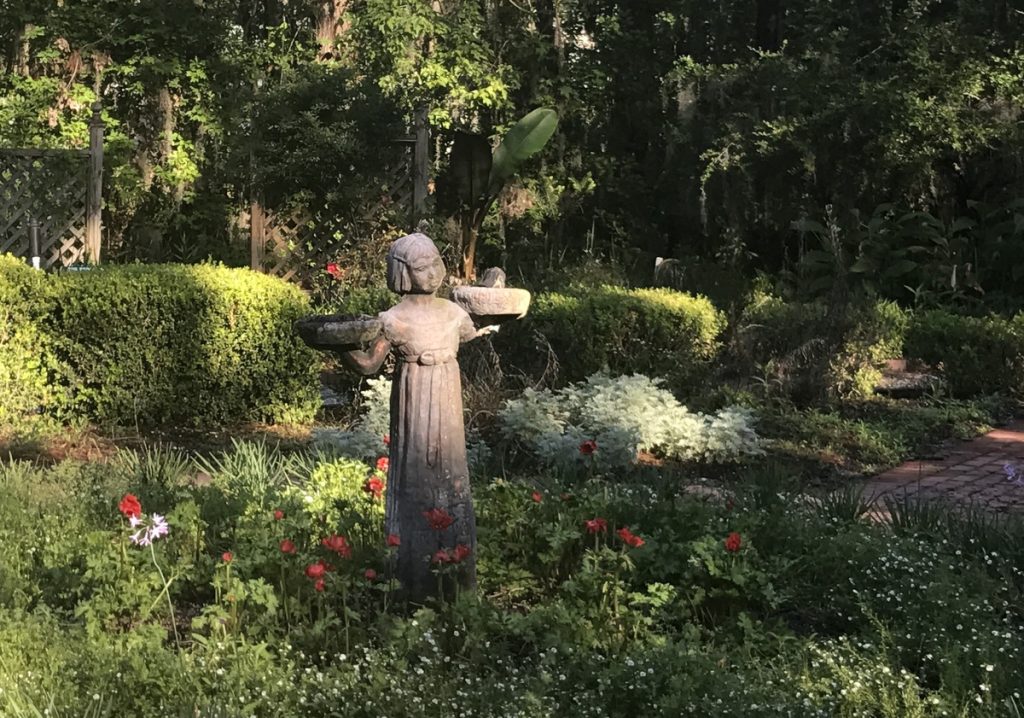 Young girl statue holding trays in a Savannah garden